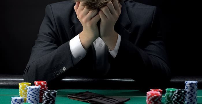 カジノのテーブルで嘆き悲しむ人の画像